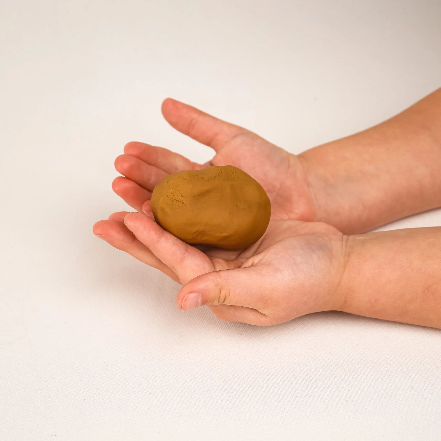 Kind spielt mit ungiftiger Bio-Knete von Noonchi Organics – Förderung der Feinmotorik nach Montessori.