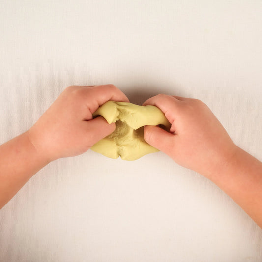 Kinderhände kneten die Bio Knete von Noonchi in Farbe Yelo Yellow