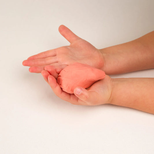 Pfirsichfarbene Bio-Knete BLOOMING Pink Noonchi Organic Detailansicht, in Kinderhänden