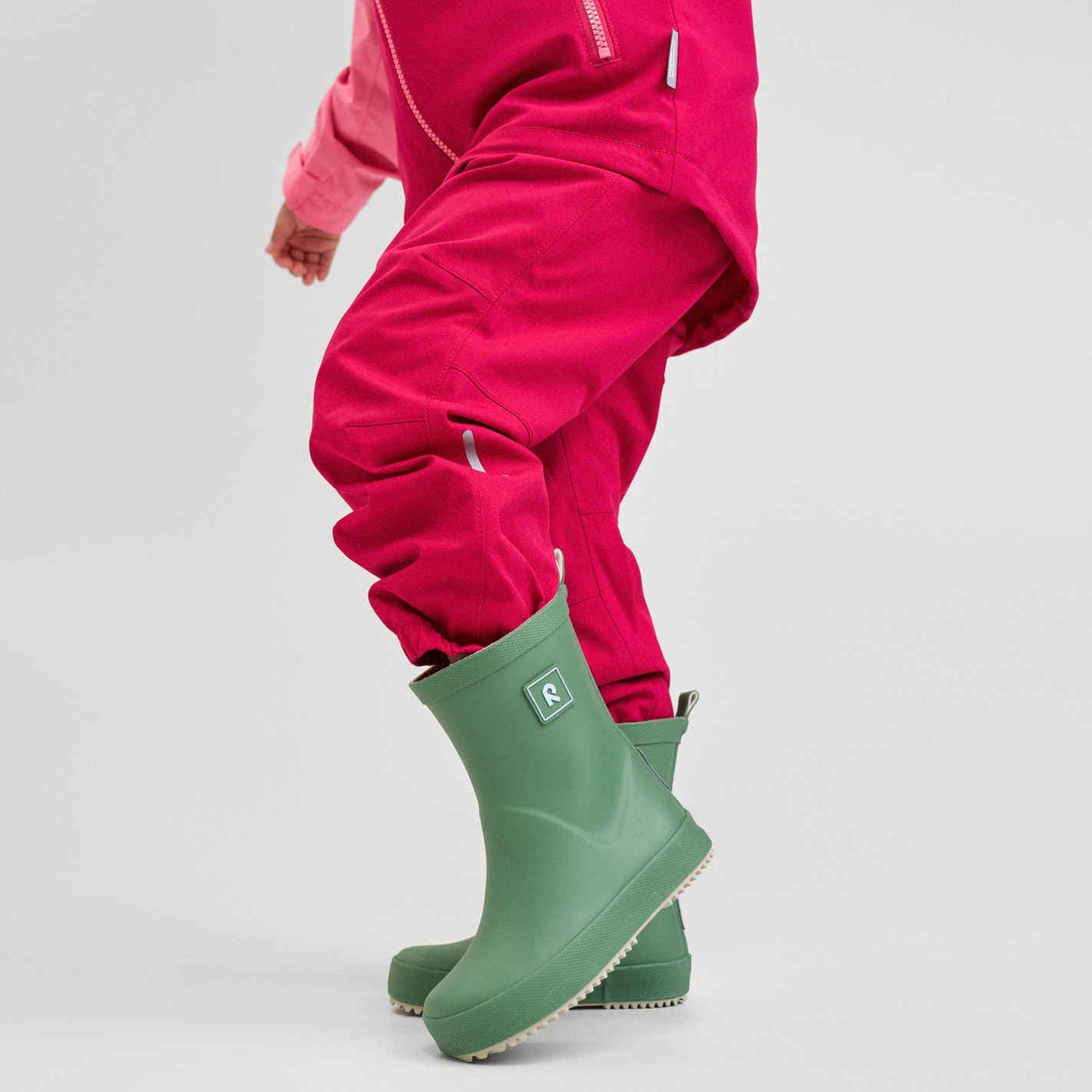 Reima-Barfuß-Gummistiefel im Vordergrund. Die Gummistiefel trägt ein Kind, das Gesicht sieht man nicht. 