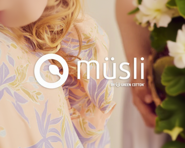 Logo von Müsli by green cotton im vordergrund, im Hinmtergrund sieht man ein Produkt und umrisse einer blume